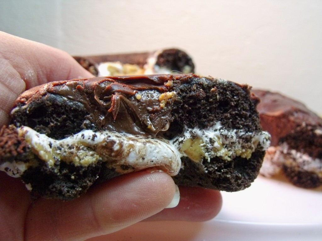 chocolate marshmallow stuffed donut held