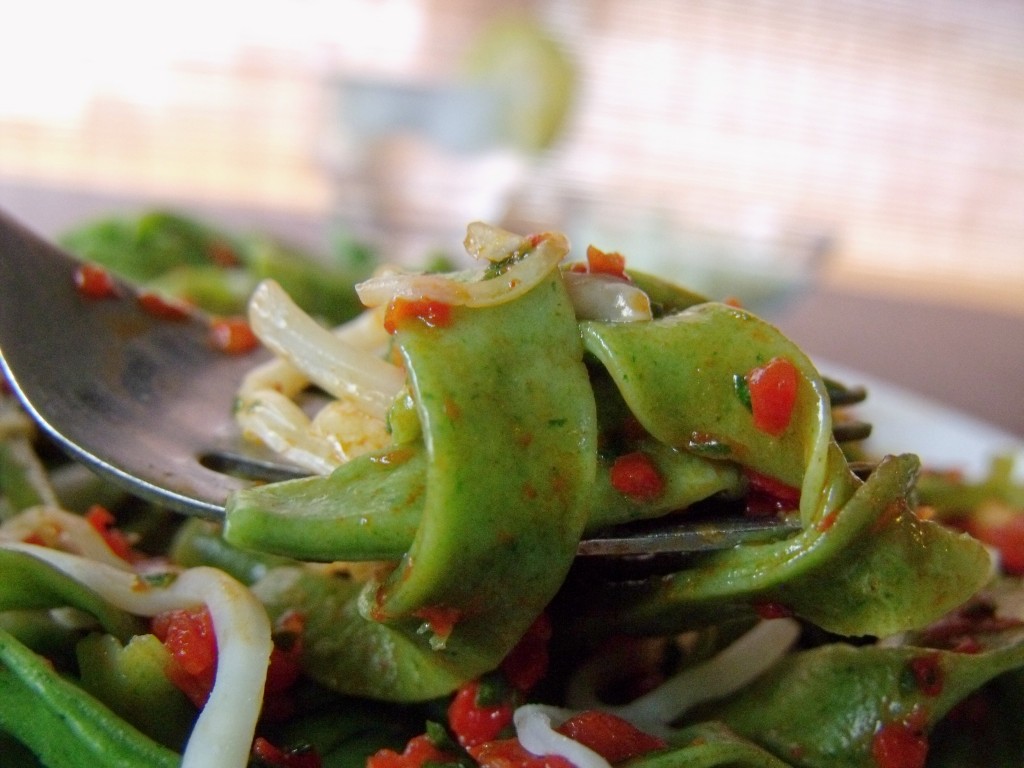 spinach pasta with red pepper sauce close up